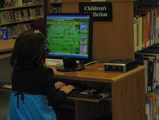 Girl playing on a computer in the library