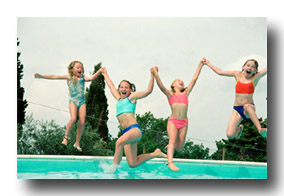 Four girls jumping into a pool